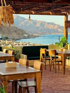 a restaurant with tables and chairs and a view of the ocean at Sea Breeze Dahab in Dahab