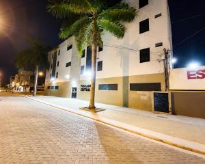 a palm tree in the middle of a street at night at Hotel Pousada Central in Feira de Santana