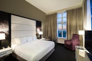 サバンナにあるB ヒストリックの大きなベッドと椅子が備わるホテルルームです。