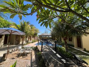 a resort with a pool and tables and palm trees at Chalés Farol Village in Fortim +64 photos