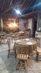 a wooden table and chairs in a restaurant at Chalés Farol Village in Fortim