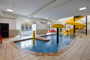 a large pool with a slide in a building at Hôtel TERRA Laurentides in Sainte-Agathe-des-Monts