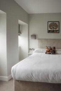a bedroom with a white bed with a tree picture on the wall at Salt Rooms in Scarborough