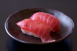 a plate with two pieces of fish on it at Ooedo Onsen Monogatari Beppu Seifu in Beppu