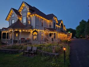 a large house with lights on the front of it at Albergo Allegria Hotel in Windham