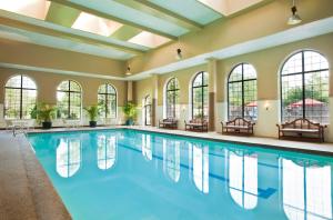 an indoor pool with windows and a large swimming pool at Dolce by Wyndham Parsippany in Parsippany