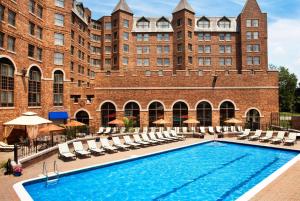 a swimming pool in front of a large brick building at Dolce by Wyndham Parsippany in Parsippany