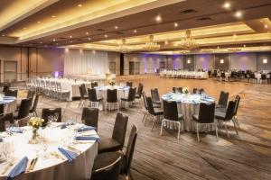 a banquet hall with white tables and chairs at Dolce by Wyndham Parsippany in Parsippany +63 photos