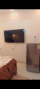 a room with a bed and a tv on the wall at Relax Holiday Guest House in Kākināda