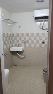 a bathroom with a white sink and a toilet at Relax Holiday Guest House in Kākināda