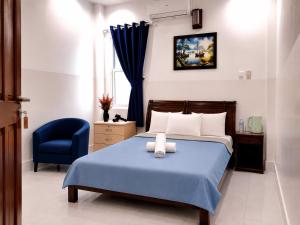 a bedroom with a bed and a blue chair at SG Cozy2 Hotel - Pham Ngu Lao Street in Ho Chi Minh City +27 photos