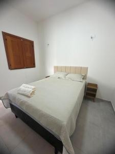 a bedroom with a large bed and a wooden door at Casa Dunas douradas in Barreirinhas +45 photos