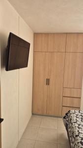 a bedroom with a bed and a flat screen tv at Your Perfect Rest Apartment with Pool and AC in Playa de Vacas