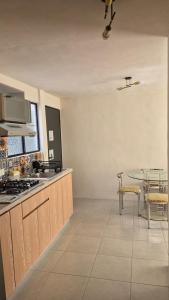 a kitchen with a stove and a table in it at Your Perfect Rest Apartment with Pool and AC in Playa de Vacas