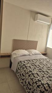 a bedroom with a bed with a comforter and a window at Your Perfect Rest Apartment with Pool and AC in Playa de Vacas +9 photos