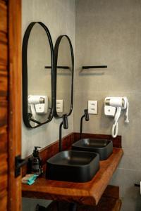 a bathroom with a black sink and a mirror at Pousada Ville Solare Garden in Santo Amaro +44 photos