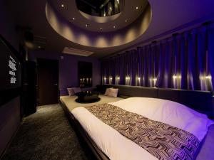 a bedroom with a large bed and a couch at FUN3 ﾌｧﾝｽﾘｰ -Adult Only- in Yokohama