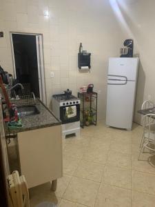 a kitchen with a refrigerator and a sink and a stove at Hostel e Camping Terapia Roots in Santa Teresinha
