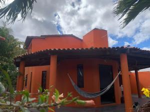 an orange house with a hammock in front of it at Hostel e Camping Terapia Roots in Santa Teresinha