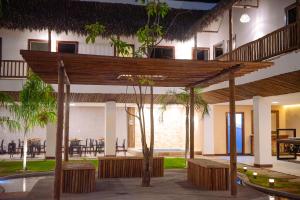 a building with a wooden pergola and a patio at Pousada Ville Solare Garden in Santo Amaro