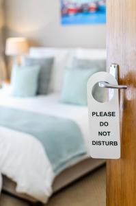 un pomo de puerta con una señal que diga: "Por favor, no molestes" en Admirals Lodge Guest House, en Port Elizabeth