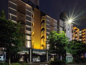 a building with a lit up facade at night at FUN3 ﾌｧﾝｽﾘｰ -Adult Only- in Yokohama