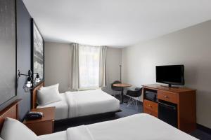 a hotel room with two beds and a flat screen tv at Hôtel TERRA Laurentides in Sainte-Agathe-des-Monts