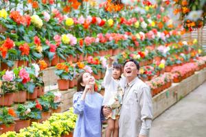 a man and a woman and child looking at flowers at Ooedo Onsen Monogatari Premium Kinugawa Kanko Hotel in Nikko