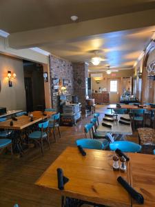 a restaurant with wooden tables and blue chairs at Albergo Allegria Hotel in Windham