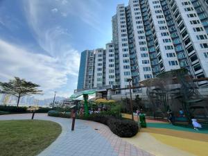 a large apartment building with a playground in a park at Kowloon Harbourfront Hotel in Hong Kong