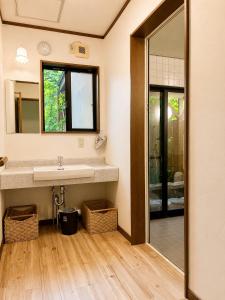 a bathroom with a sink and a mirror at Anise Garden Lodge in Hakuba +24 photos