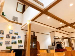 a dining room with wooden ceilings and wooden chairs at Anise Garden Lodge in Hakuba