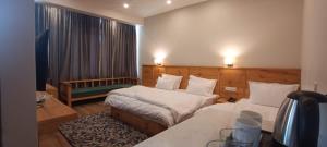 a hotel room with two beds and a window at Sintik Residency in Leh