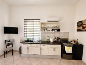 a kitchen with a sink and a stove in it at CasaLoca Cabarete Studio Apartment in Cabarete