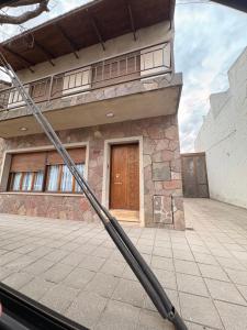 a building with a wooden door in front of it at Casa Encuentro in Pringles