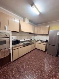 a kitchen with white cabinets and a refrigerator at Casa Encuentro in Pringles