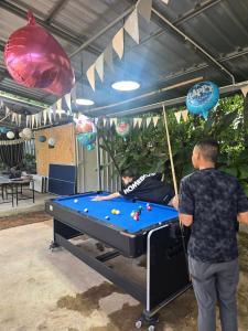 two men standing near a pool table in a garage at Chaba3 in Ban Nong Bua Noi