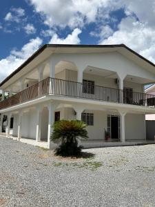 a large white building with a palm tree in front of it at hotel paiol mutum in Nova Mutum