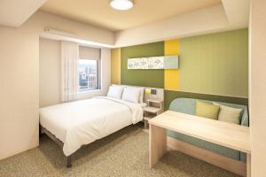 a bedroom with two beds and a window and a bench at たびのホテルlit豊川 in Toyokawa