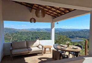 a living room with a couch and a table with a view at Chalet Alta Vista Acuruí in Itabirito