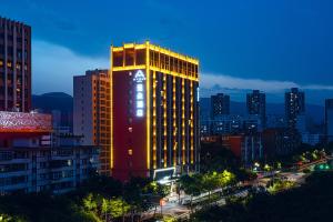 a tall building with a clock on the side of it at Atour Hotel Lanzhou Xigu in Lanzhou