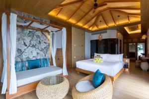 a bedroom with two beds and a table and chairs at SINAE Phuket Luxury Hotel in Phuket