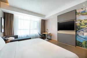 a hotel room with a bed and a flat screen tv at Atour Hotel Lanzhou Xigu in Lanzhou