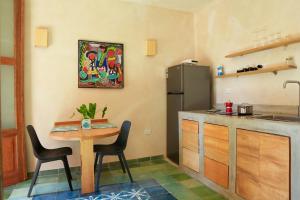 a kitchen with a table and a refrigerator at Domus Santa Barbara Apartments with Pool in Santo Domingo