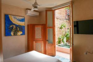 a bedroom with a bed and a door and a window at Domus Santa Barbara Apartments with Pool in Santo Domingo