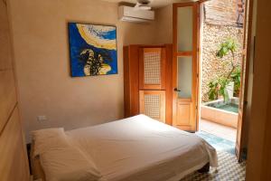 a bedroom with a bed and a painting on the wall at Domus Santa Barbara Apartments with Pool in Santo Domingo +70 photos