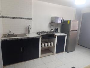 a small kitchen with a stove and a refrigerator at Práctico y céntrico departamento in Salamanca