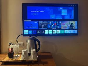a tv sitting on top of a table with a coffee pot at Chakungrao Riverview Hotel in Kamphaeng Phet +21 photos