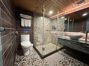 a bathroom with a shower and a toilet and a sink at Cai She Hotel in Taipei