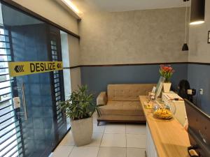 ein Wohnzimmer mit Sofa und Tisch in der Unterkunft Pousada Sol do Centro - Dom Kilmer in Fortaleza